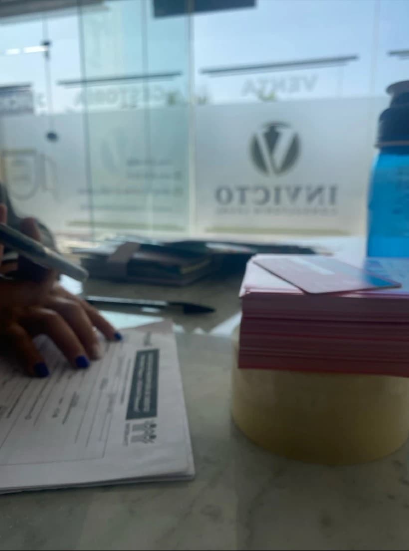Cliente firmando documentos en la oficina de Invicto